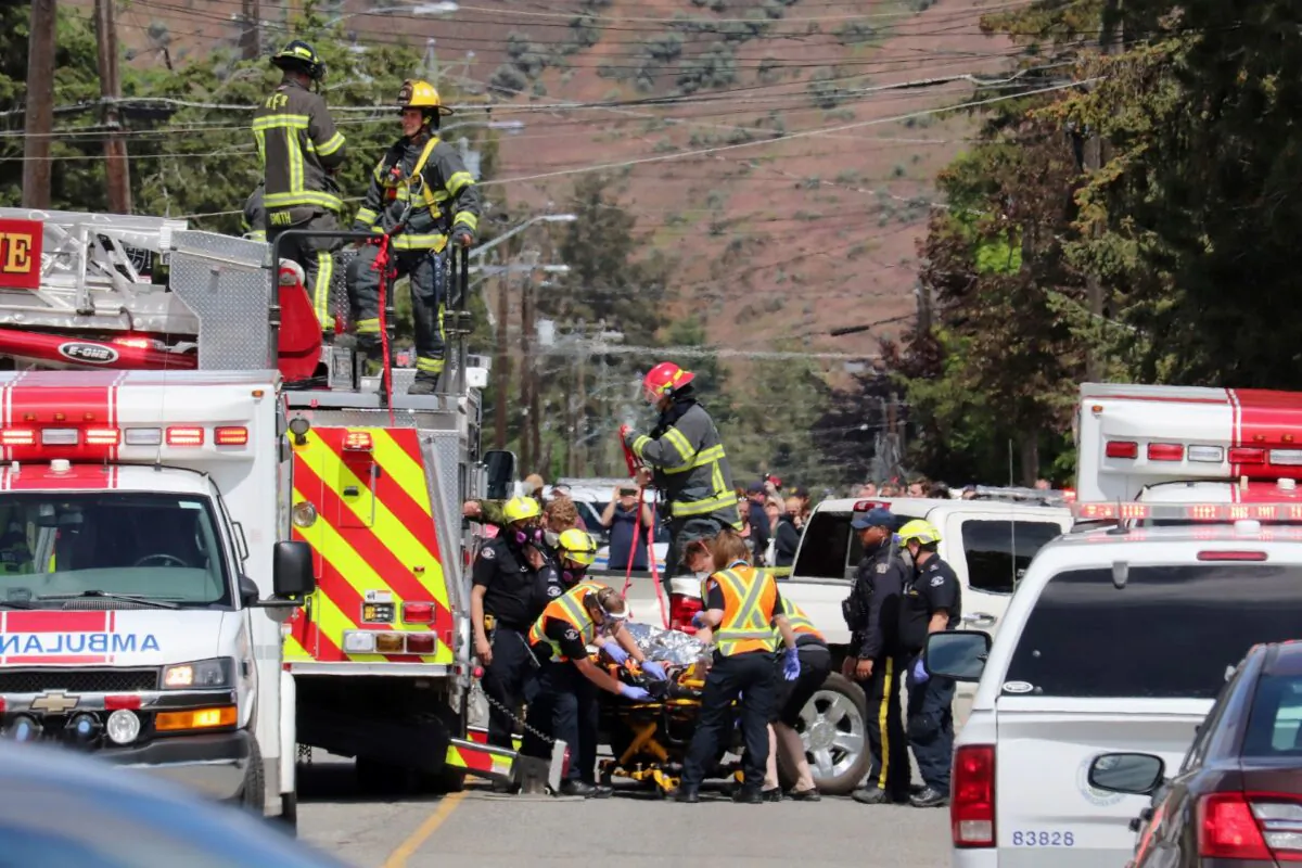 First responders transport an injured person on a stretcher at the scene of a crash involving a Canadian Forces Snowbirds aircraft in Kamloops, British Columbia, Canada, on May 17, 2020. (Brendan Kergin/Castanet Kamloops/The Canadian Press via AP)