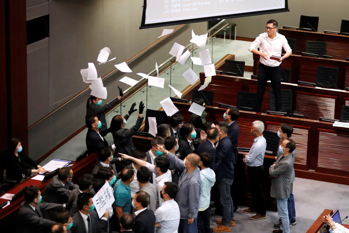 Pan-democratic legislator Lam Cheuk-ting tears and scatters the Rule of Procedure paper during the Legislative Council’s House Committee meeting in Hong Kong on May 18, 2020. (Tyrone Siu/Reuters)