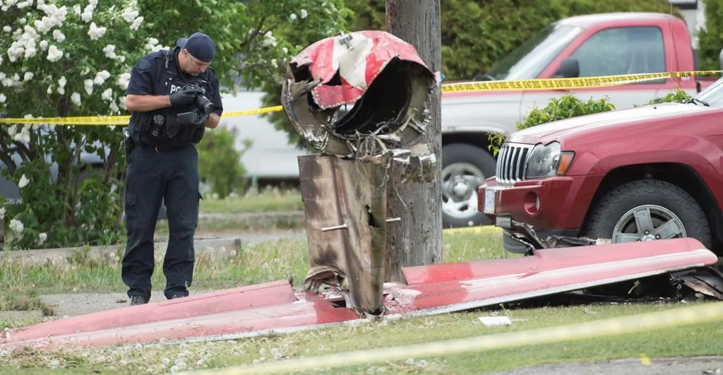 An RCMP photographer photographs the remains of a downed Canadian Forces Snowbird plane in Kamloops, B.C., on May 17, 2020. (The Canadian Press/Jonathan Hayward)