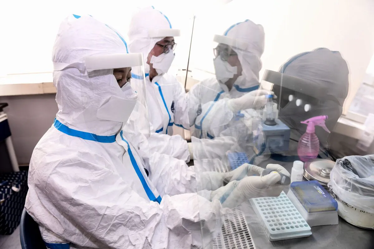 Laboratory technicians work on testing samples from people to be tested for the CCP virus at a laboratory in Shenyang, China, on Feb. 12, 2020. (STR/AFP via Getty Images)