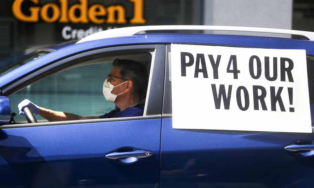 A driver wears a face mask and gloves during a caravan protest calling for California to enforce the AB 5 law, in Los Angeles on April 16, 2020. (Mario Tama/Getty Images)