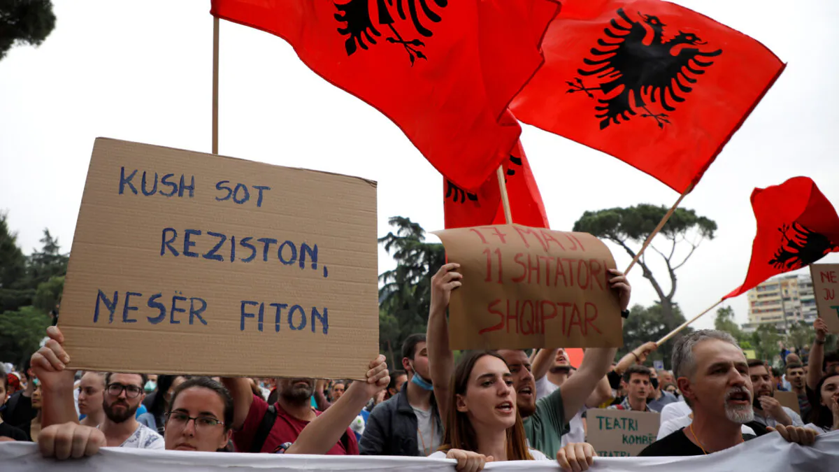 A woman holds a sign reading "Who resists today wins tomorrow" as she attends a protest against the demolition of the National Theatre, during the outbreak of the coronavirus disease (COVID-19), in Tirana, Albania May 18, 2020. (Florion Goga/Reuters)
