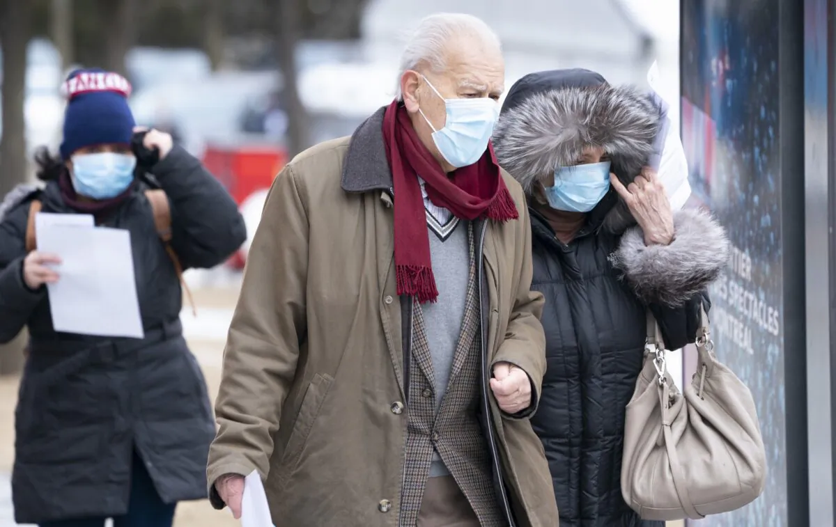 An elderly couple waits in a lineup outside a walk-in COVID-19 test clinic in Montreal on March 23, 2020. (The Canadian Press/Paul Chiasson)