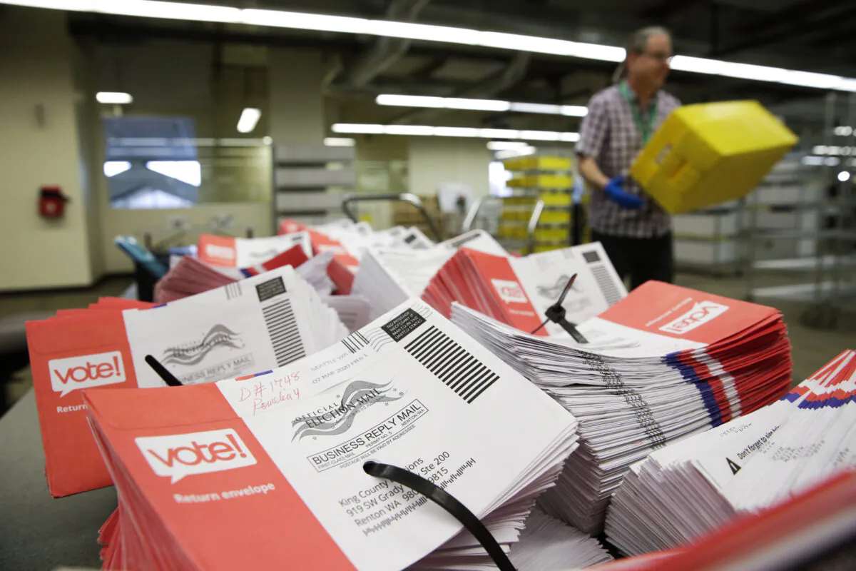 Empty envelopes of opened vote-by-mail ballots for the presidential primary are stacked on a table at King County Elections in Renton, Wash., on March 10, 2020. (Jason Redmond/AFP via Getty Images)