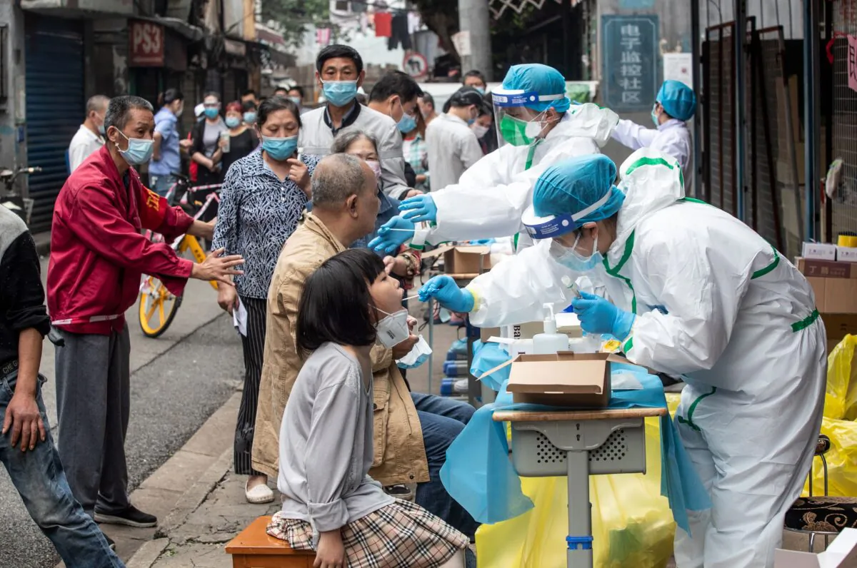 Medical workers take swab samples from residents to be tested for the COVID-19 coronavirus, in a street in Wuhan in China's central Hubei province on May 15, 2020.(STR/AFP via Getty Images)