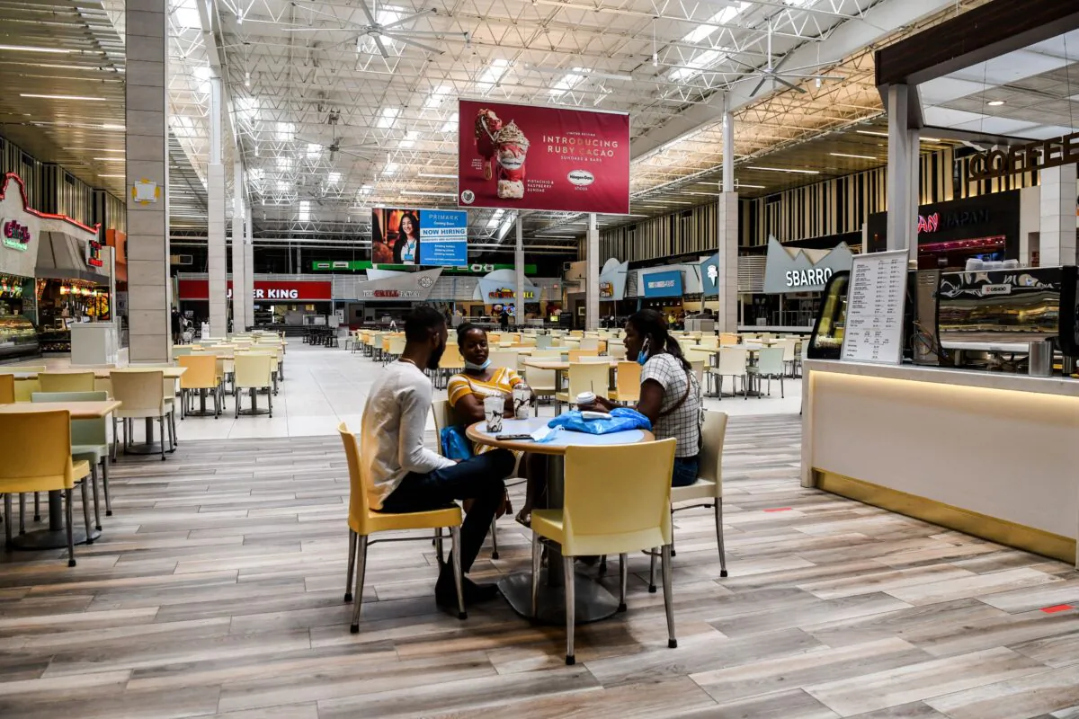 People eat in a deserted food court inside a mall west of Fort Lauderdale, Fla., on May 18, 2020. (Chandan Khanna/AFP via Getty Images)