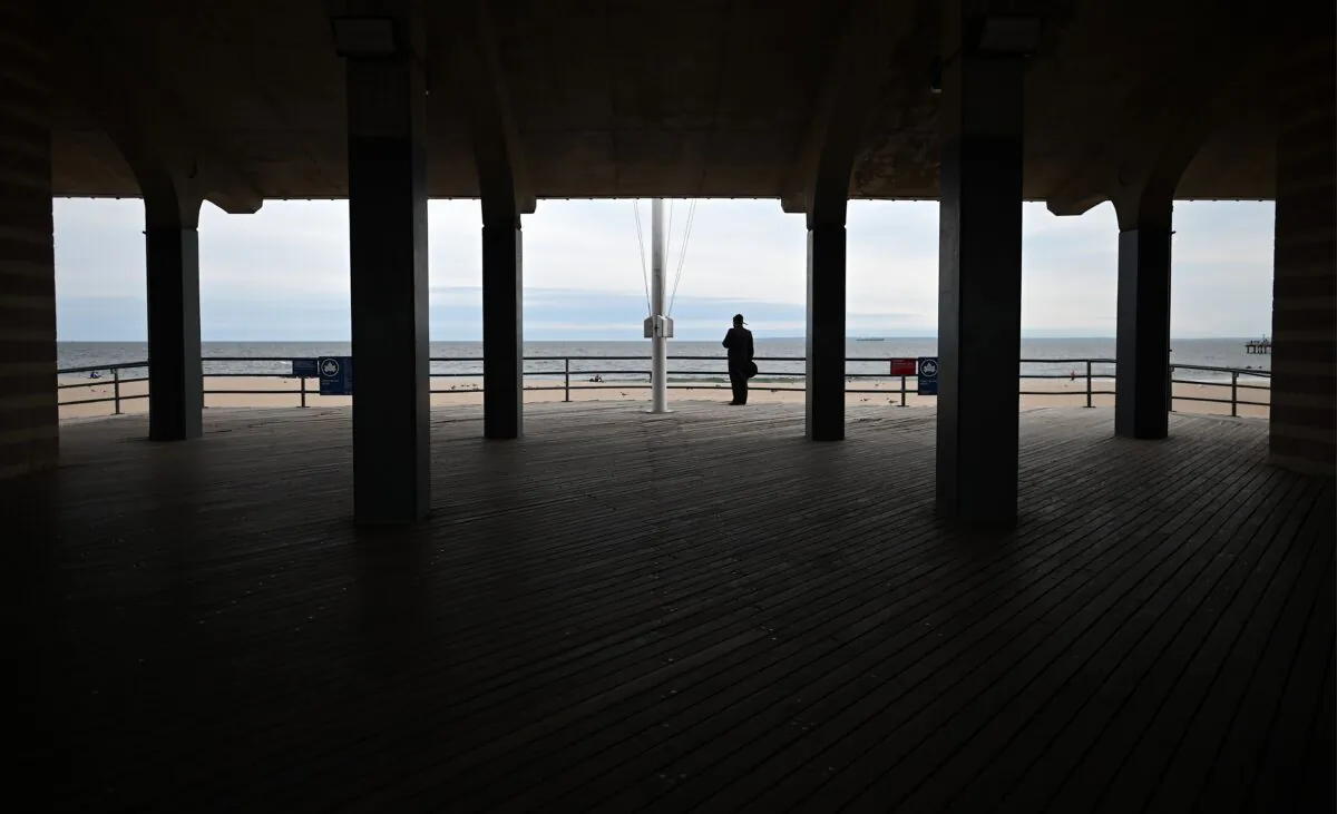 A man wearing a mask stands at the promenade at Coney Island Beach in New York City on May 18, 2020. (Johannes Eisele/AFP via Getty Images)