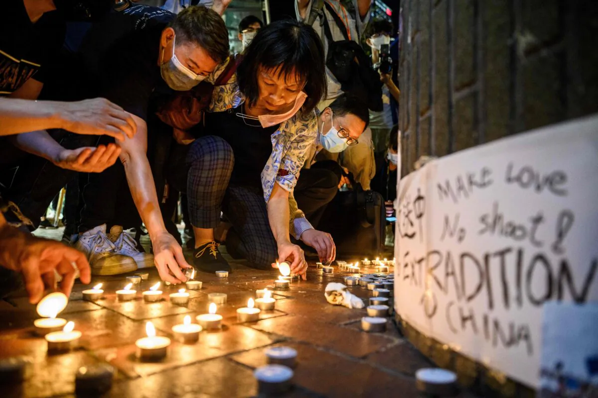 Pro-democracy protesters light candles during a vigil outside the Pacific Place shopping mall in the Admiralty area of Hong Kong on May 15, 2020. (Anthony Wallace/AFP via Getty Images)