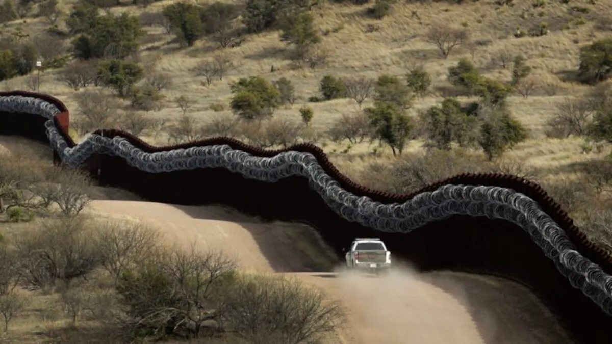 A Customs and Border Control agent patrolling on the U.S. side of a razor-wire-covered border wall along the Mexico east of Nogales, Ariz., on March 2, 2019. (Charlie Riedel/AP Photo)