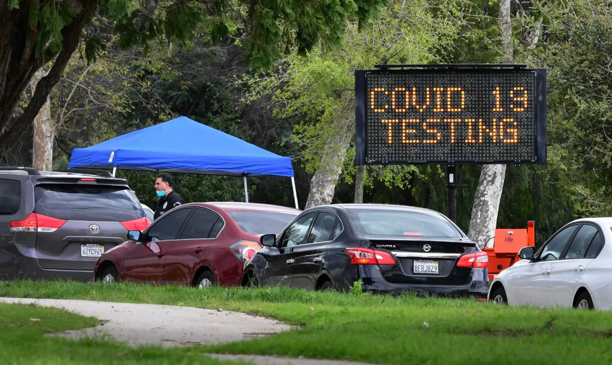 A police officer mans the entrance to a coronavirus (Covid-19) testing center in Hansen Dam Park in Pacoima, Calif., on March 25, 2020. (Frederic J. Brown/AFP via Getty Images)
