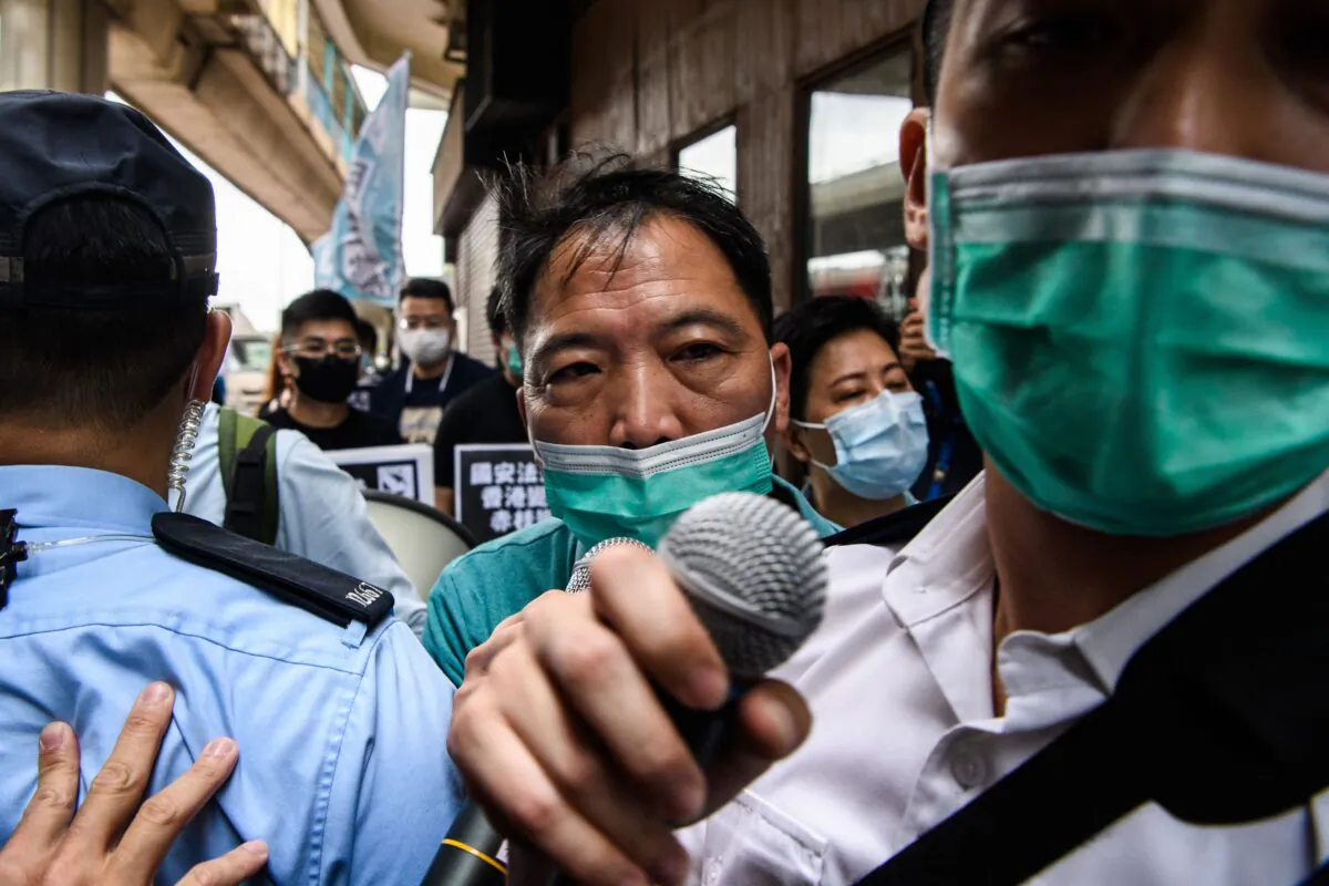 Police issue protesters with fines for breaking social distancing rules in Hong Kong on May 22, 2020. A proposal to enact new Hong Kong security legislation was submitted to China's rubber-stamp on May 22, a move expected to fan fresh protests in the semi-autonomous financial hub. (ANTHONY WALLACE/AFP via Getty Images)