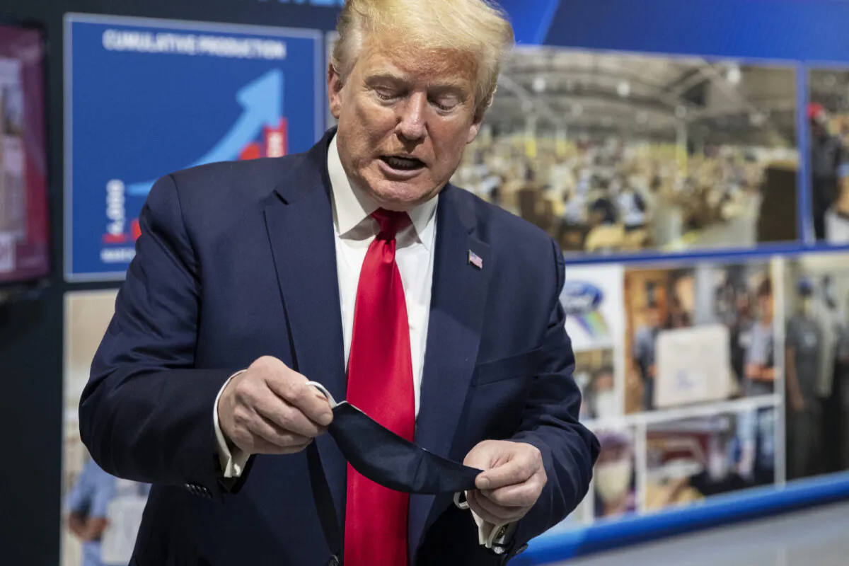 President Donald Trump holds his mask as he speaks while touring Ford's Rawsonville Components Plant, in Ypsilanti, Mich., on May 21, 2020. (Alex Brandon/AP Photo)