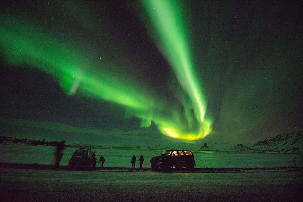 Tourists photograph the Northern Lights at lake Thingvellir, Iceland, on Jan. 13, 2016. (Halldor Kolbeins/AFP via Getty Images)