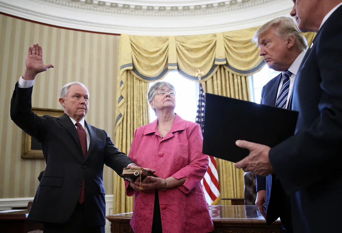 President Donald Trump watches as Jeff Sessions, left, is sworn in as the new Attorney General by Vice President Mike Pence, right, in the Oval Office of the White House in Washington February 9, 2017. Also pictured is Sessions's wife, Mary,, holding the Bible. (Win McNamee/Getty Images)