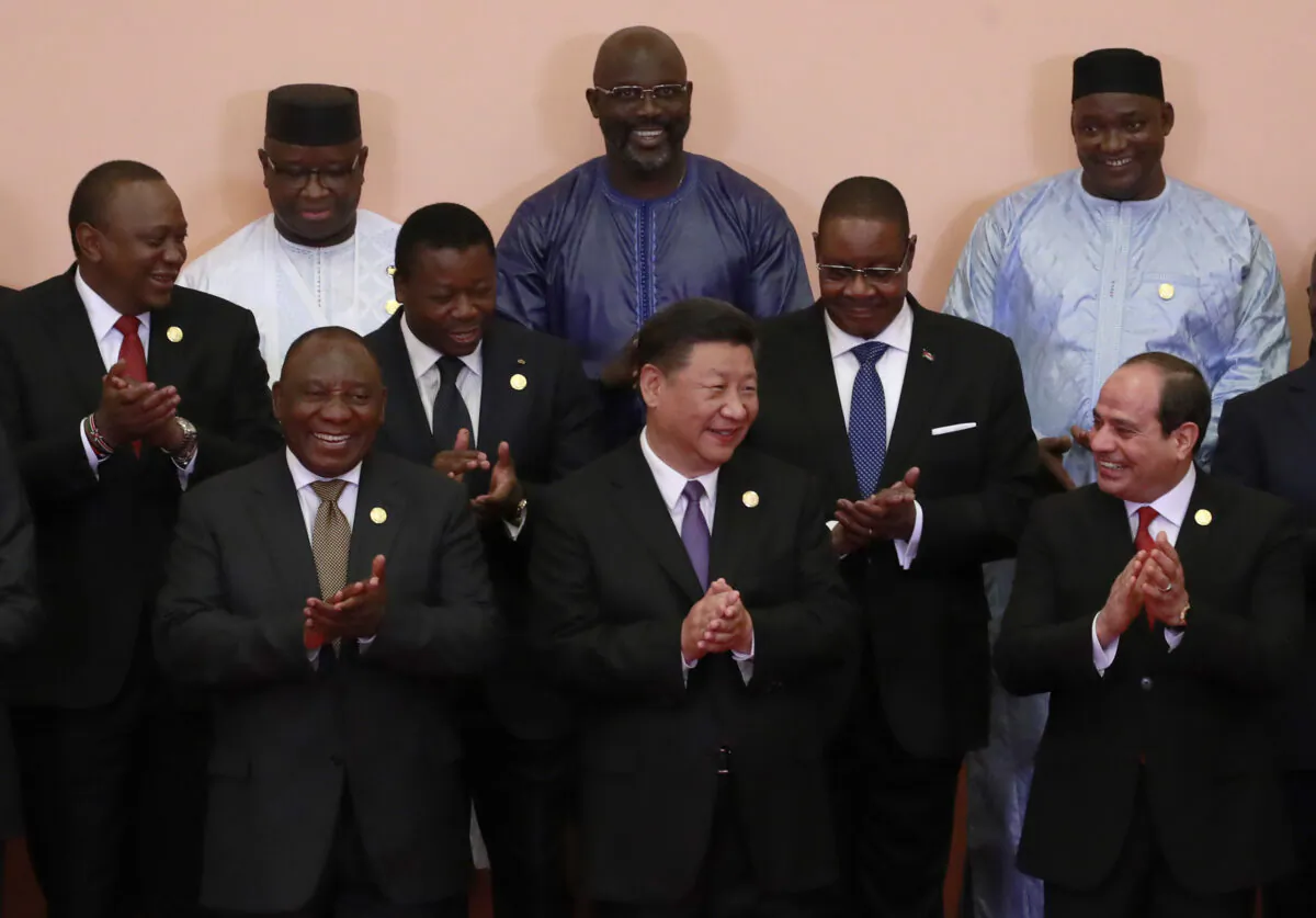 Chinese Communist Party leader Xi Jinping (front C), South African President Cyril Ramaphosa (front 3-L), Egyptian President Abdel Fattah al-Sisi (front L), Kenya’s President Uhuru Kenyatta (2nd row L), Togo’s President Faure Gnassingbé (2nd row C), Malawi's President Arthur Peter Mutharika (2nd row R), Sierra Leone President Julius Maada Bio (last row L), Liberian President George Weah (last row C) and other African leaders applaud during a group photo session during the Forum on China-Africa Cooperation (FOCAC) 2018 Beijing Summit on Sept. 3, 2018. (How Hwee Young /Pool/Getty Images)
