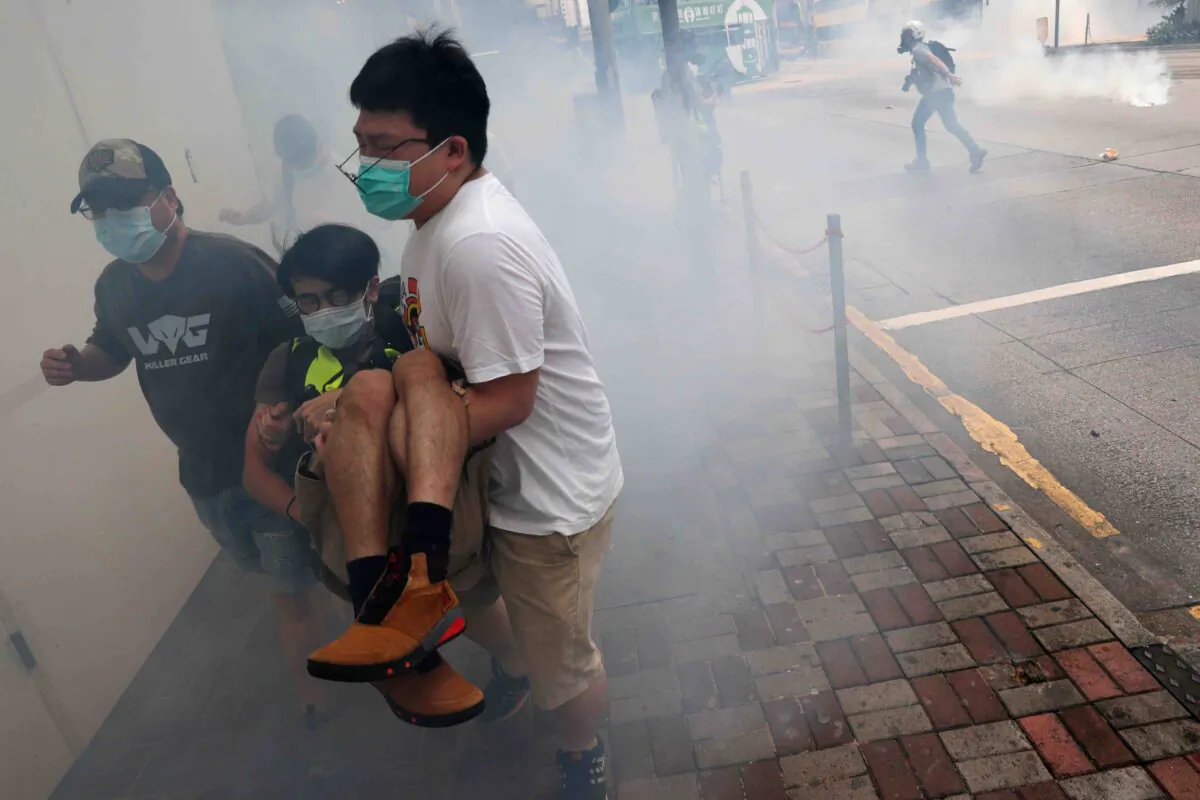Protesters run away from tear gas during a march against Beijing’s plans to impose national security legislation in Hong Kong on May 24, 2020. (Tyrone Siu/Reuters)