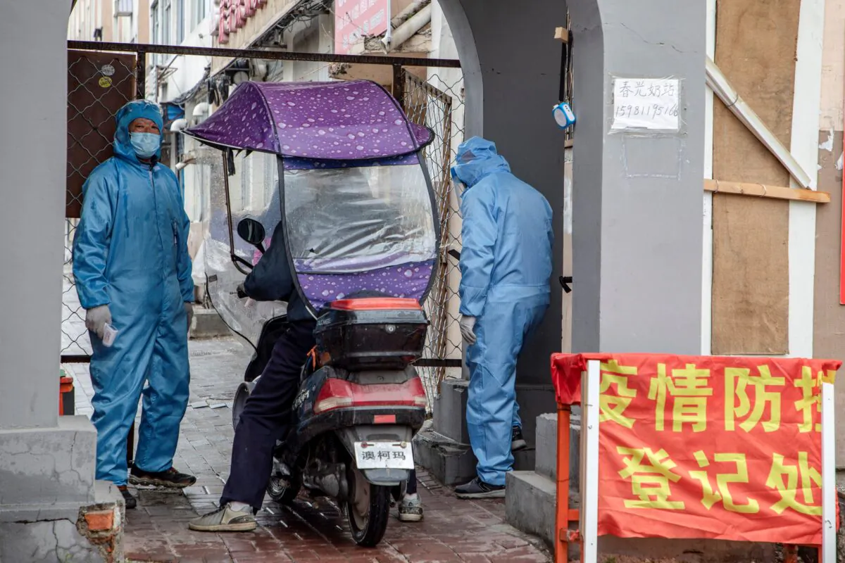 Volunteers check the identity of a resident at the entrance of a residential compound in Jilin city, China, on May 22, 2020. (STR/AFP via Getty Images)