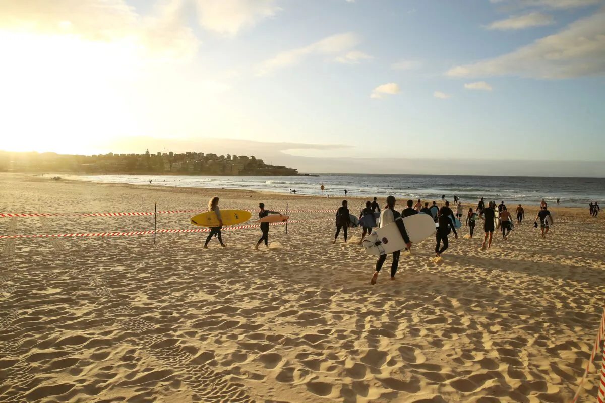 Surfers walk to the water along a designated walkway after the 7am reopening of Bondi Beach on April 28, 2020 in Sydney, Australia. (Mark Kolbe/Getty Images)