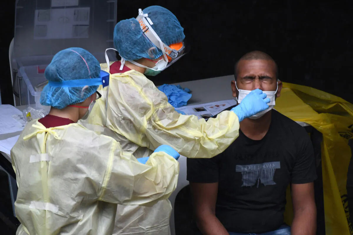 A health care worker collects a nasal swab sample for a COVID-19 test in Singapore, on April 27, 2020. (Roslan Rahman/AFP/Getty Images)