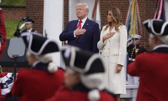 President Donald Trump and First Lady Melania Trump hold their hands over their hearts for the National Anthem during ceremonies commemorating the Memorial Day holiday at Fort McHenry in Baltimore, Md., on May 25, 2020. (Joshua Roberts/Reuters)