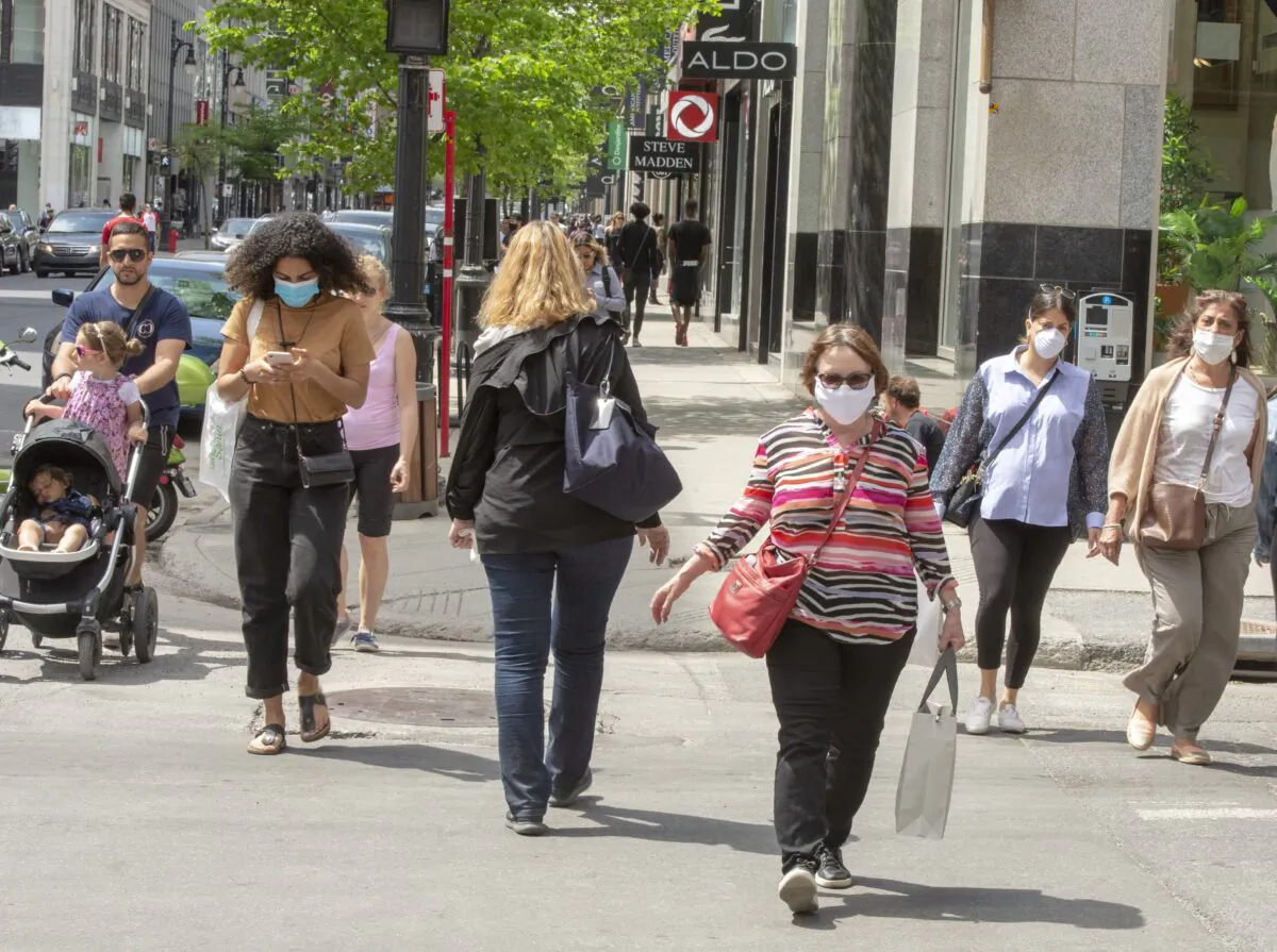 People walk along Sainte-Catherine Street in Montreal as many non-essential businesses are allowed to re-open, on May 25, 2020. (The Canadian Press/Ryan Remiorz)