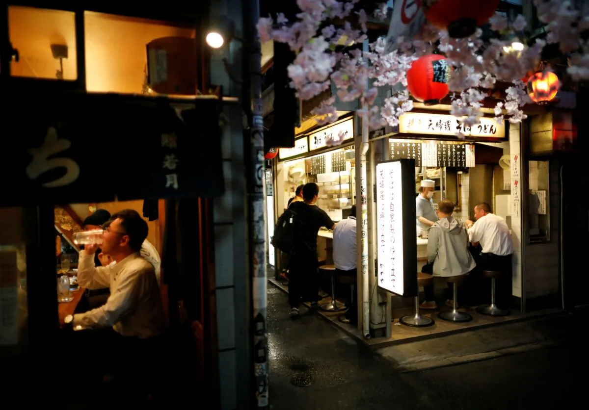 People enjoy drinks and dinner following the CCP virus outbreak at the partially reopened Japanese drinking bars alley, on the first day after the Japanese government lifted the state of emergency at Shinjuku district in Tokyo, Japan, on May 26, 2020. (Issei Kato/Reuters)