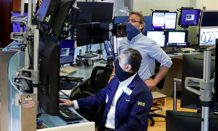 Traders wearing masks work on the first day of in-person trading since the closure during the COVID-19 outbreak on the floor at the New York Stock Exchange in New York on May 26, 2020. (Brendan McDermid/Reuters)