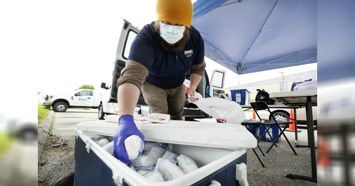 Des Moines Area Religious Council Food Pantry worker Patrick Minor pulls a package of ground pork out of a cooler during a pantry stop on May 20, 2020, in Des Moines, Iowa. (Charlie Neibergall/AP)