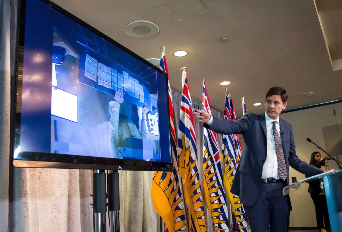 B.C. Attorney General David Eby gestures while showing a video of bundles of cash brought to a casino by an individual, during a news conference in Vancouver on June 27, 2018. An inquiry into money laundering in B.C. resumed this week. (The Canadian Press/Darryl Dyck)