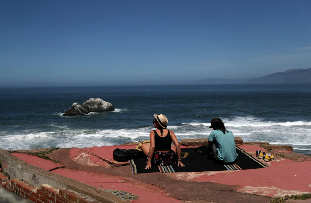 A couple sits on a rock overlooking Ocean Beach in San Francisco, Calif. on May 26, 2020. (Justin Sullivan/Getty Images)