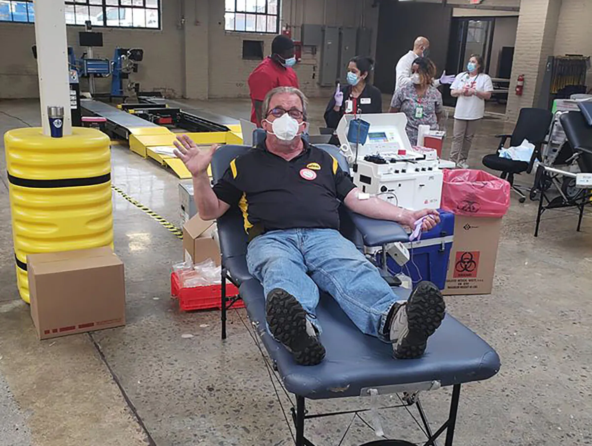 Mark Smith (C) is encouraging his Richmond, Virginia community to perform an act of kindness everyday for the month of June. (Courtesy of Midas of Richmond)