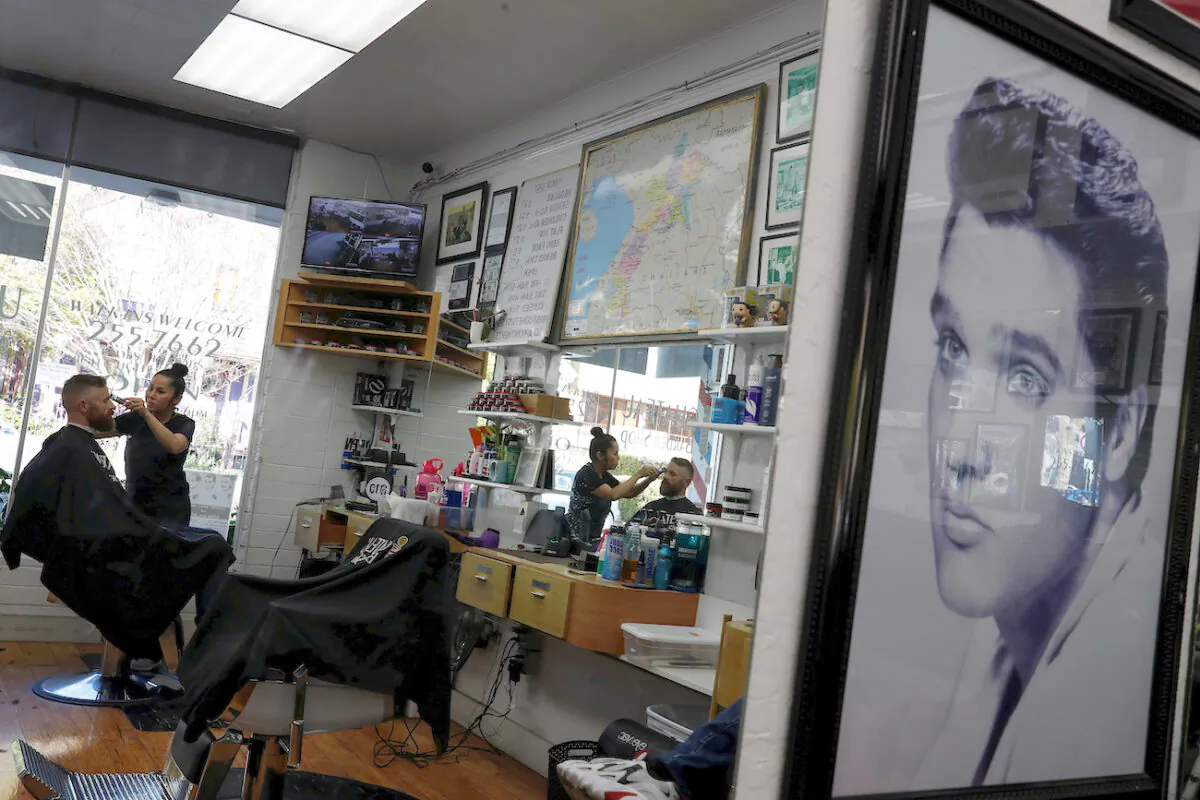 Ryan Tippins, a UPS worker living in Napa, gets a haircut from San Yankee, co-owner and barber at the Chateau Barber Shop, in Napa, California, on March 19, 2020. (Shannon Stapleton/File Photo/Reuters)