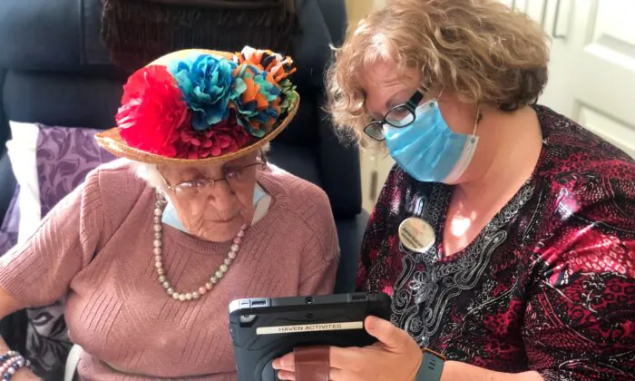 Joanne Hubbard, executive director at Kensington Place, helps a resident use a device. (Andrea Obston/Courtesy of Kensington Place)