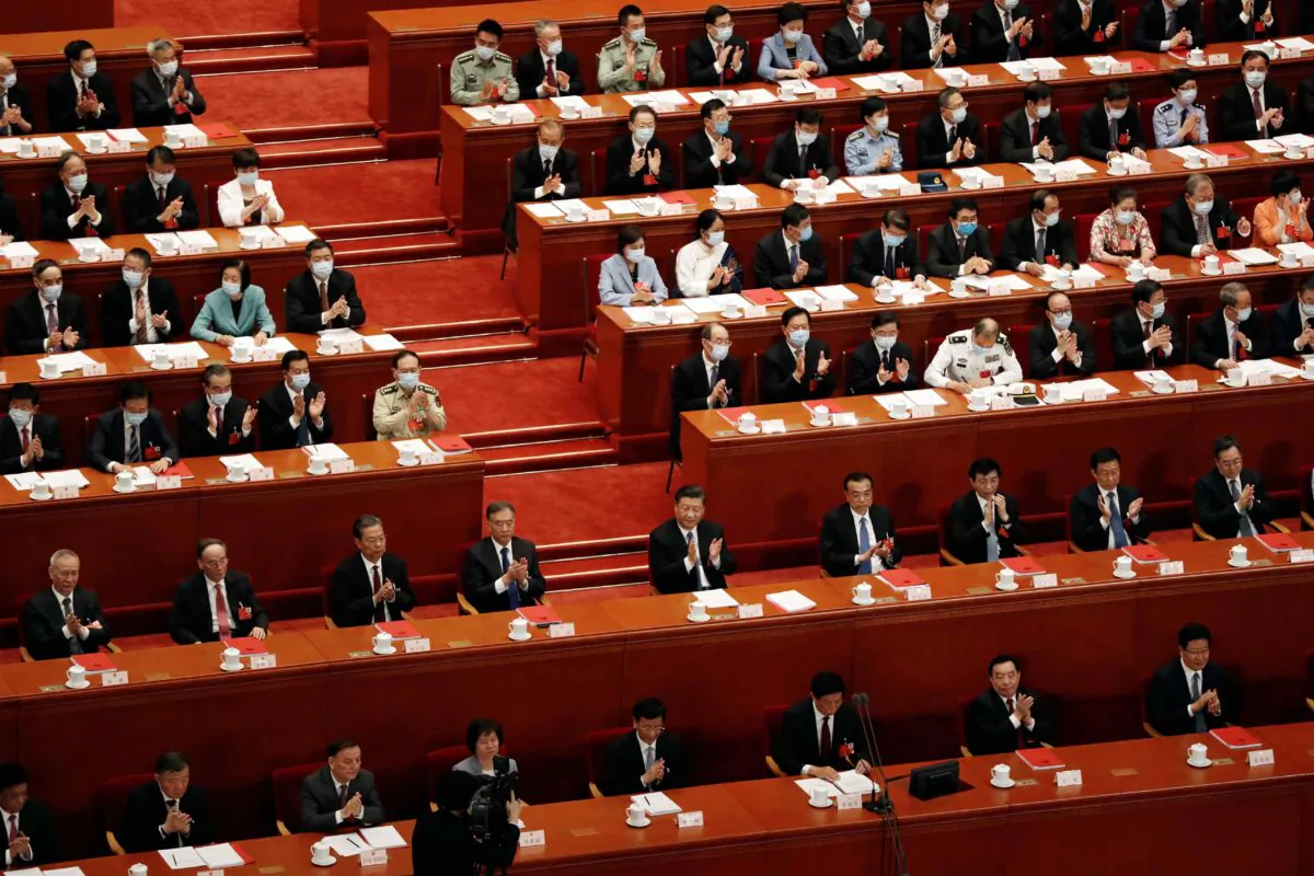 Chinese leader Xi Jinping and other officials applaud after the vote on the national security legislation for Hong Kong Special Administrative Region at the closing session of the National People's Congress (NPC) at the Great Hall of the People in Beijing, China, on May 28, 2020. (Carlos Garcia Rawlins/Reuters)