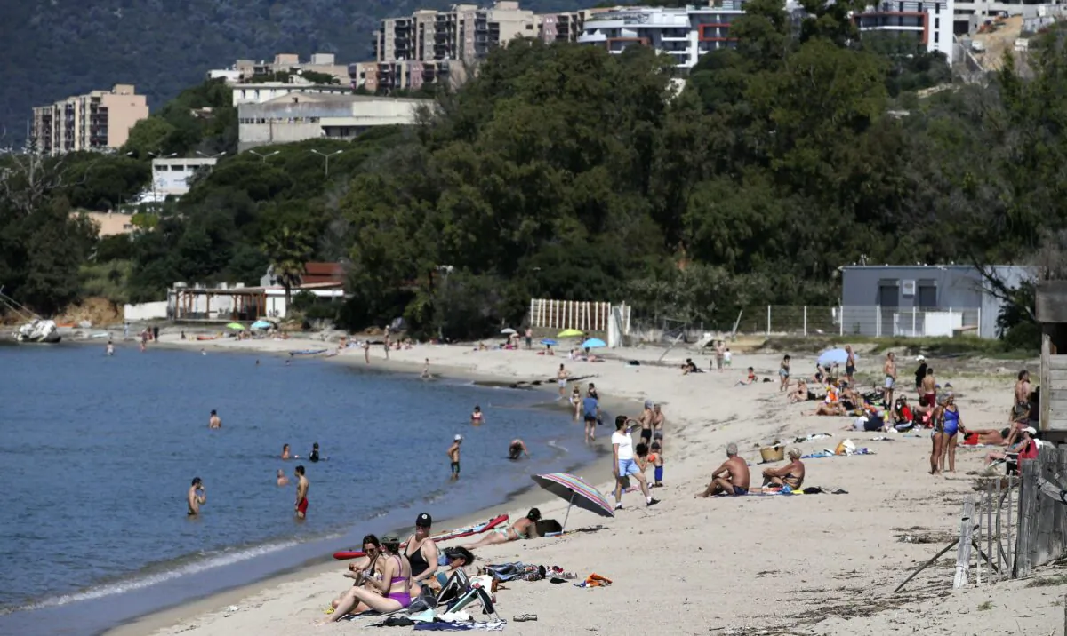 People enjoy the Ricanto beach in Ajaccio on May 21, 2020 as nearly all island beaches reopened on the French Mediterranean island of Corsica. (Pascal Pochard-Casabianca/AFP via Getty Images)