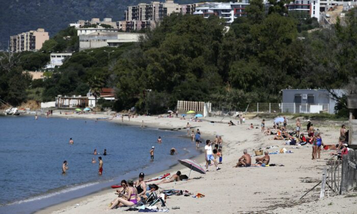 People enjoy the Ricanto beach in Ajaccio on May 21, 2020 as nearly all island beaches reopened on the French Mediterranean island of Corsica. (Pascal Pochard-Casabianca/AFP via Getty Images)