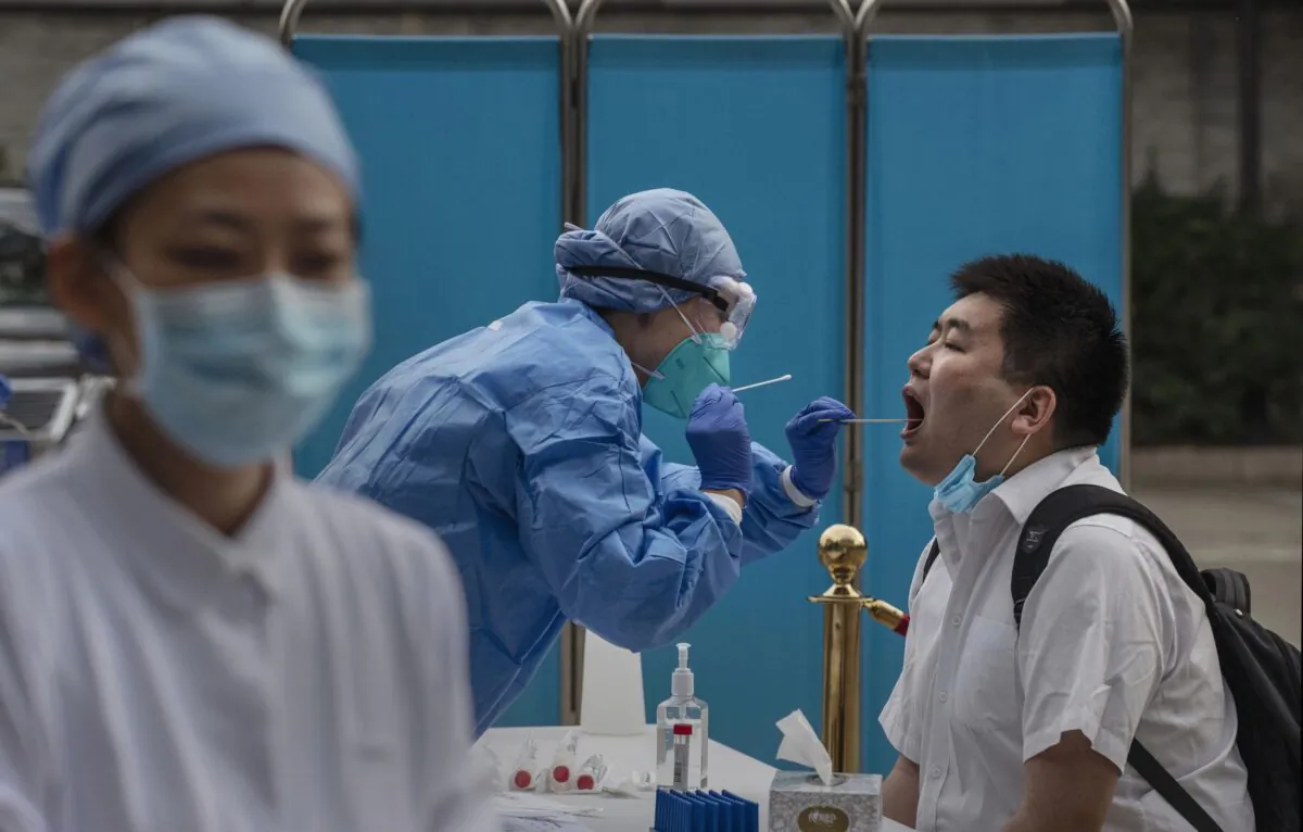 A Chinese health worker carries out a nucleic acid test on a journalist covering events around the National People's Congress in Beijing, China on May 28, 2020. (Kevin Frayer/Getty Images)