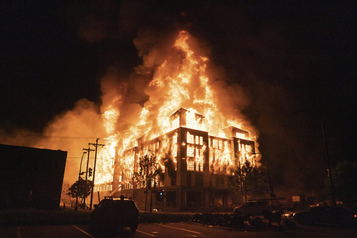 A multi-story affordable housing complex burns