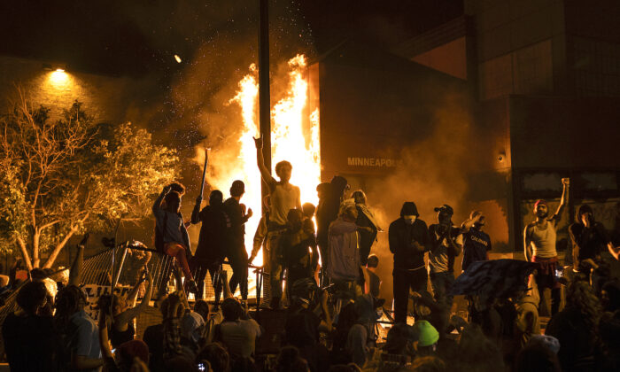 Rioters cheer as the Third Police Precinct burns behind them in Minneapolis, Minn., on May 28, 2020. (Stephen Maturen/Getty Images)