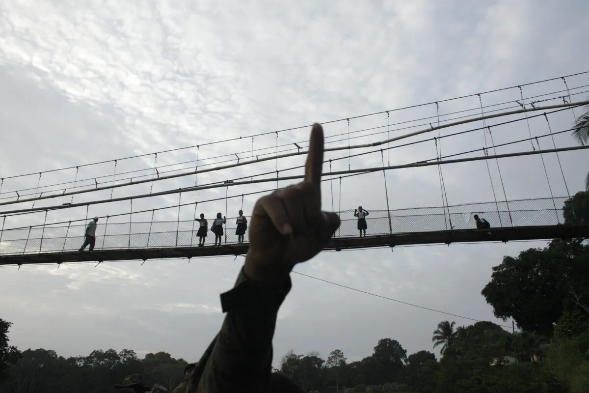 A Panama border police officer points as he begins to patrol in the Darien Province, on the border with Colombia, in Yaviza, Panama on Jun. 19, 2018. (Arnulfo Franco/AP Photo)