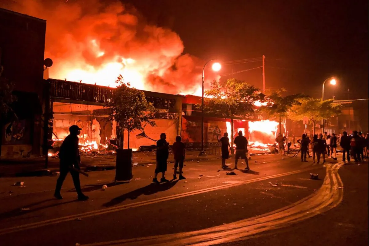Flames rise from a liquor store and shops near the Third Police Precinct in Minneapolis, Minn., on May 28, 2020. (Kerem Yucel/AFP via Getty Images)