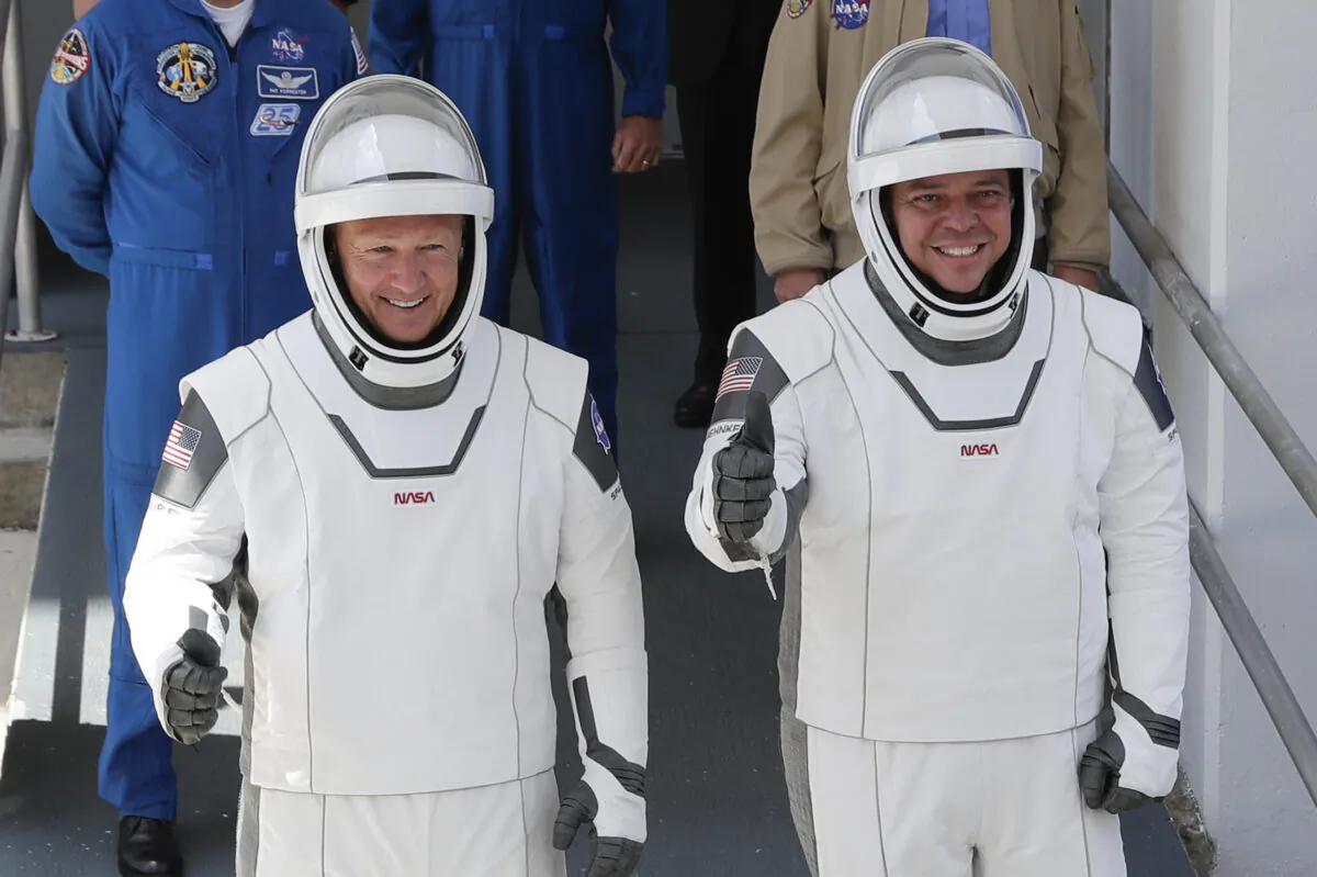NASA astronauts Douglas Hurley (L) and Robert Behnken walk out of the Neil A. Armstrong Operations and Checkout Building on their way to Pad 39-A, at the Kennedy Space Center in Cape Canaveral, Fla., on May 30, 2020. (John Raoux/AP photo)