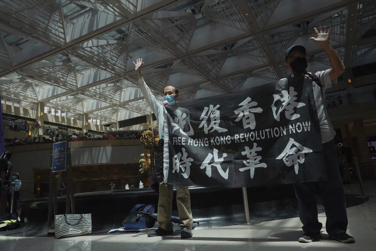 Protesters gesture with five fingers, signifying the "Five demands, not one less" in a shopping mall during a protest against China's national security legislation for the city, in Hong Kong on June 1, 2020. (Vincent Yu/AP Photo)
