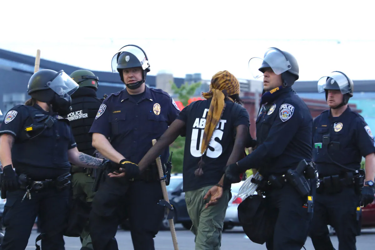 A protester is detained by State Police after staying out beyond the governor’s 8 p.m. curfew during the sixth night of protests and violence following the death of George Floyd, in Minneapolis, Minn., on May 31, 2020. (Charlotte Cuthbertson/The Epoch Times)