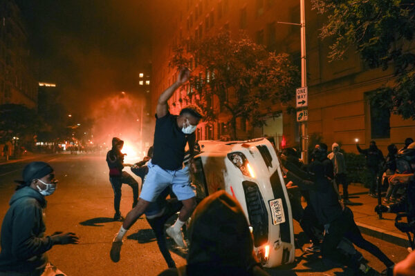 Demonstrators vandalize a car