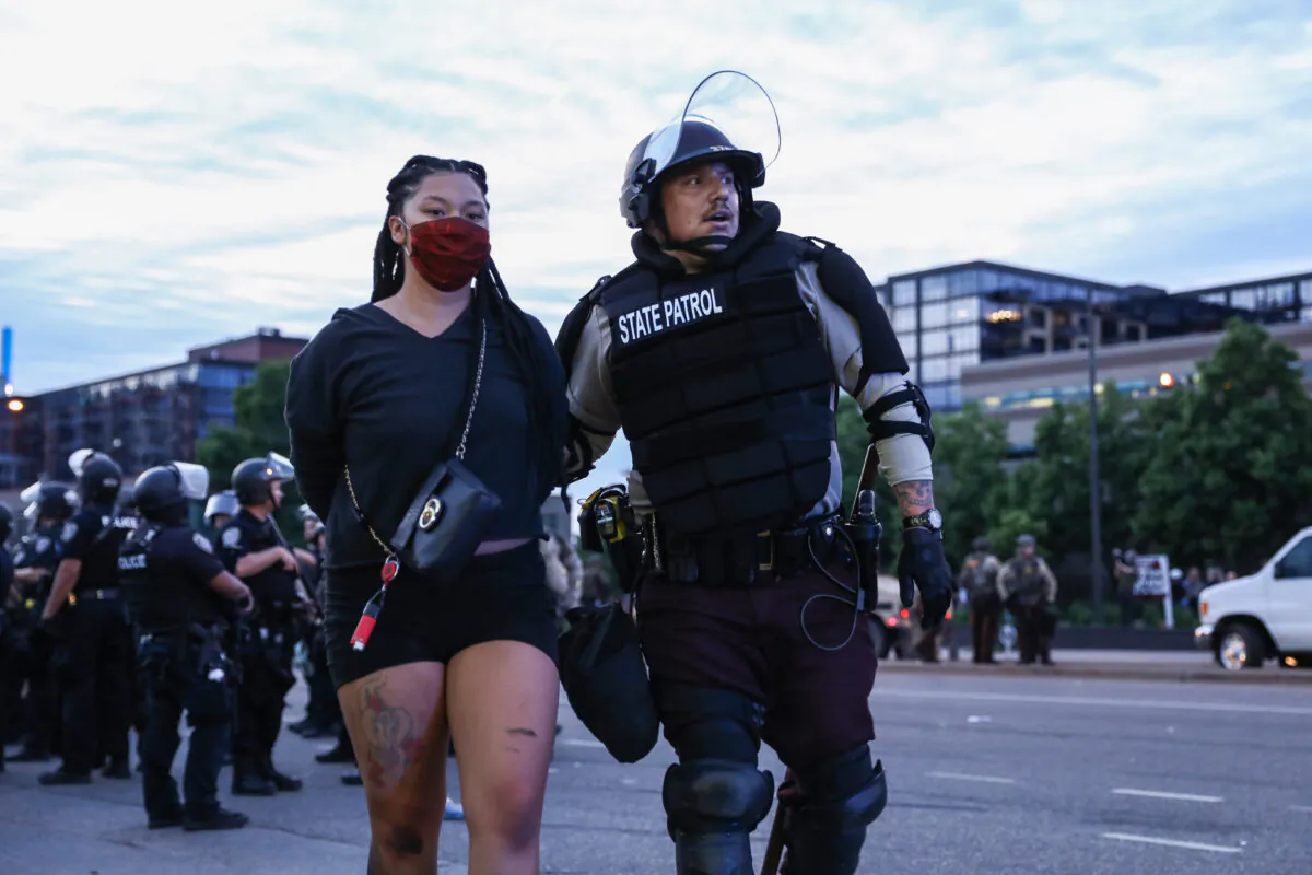 A protester is detained by State Police after staying out beyond the governor’s 8 p.m. curfew during the sixth night of protests and violence following the death of George Floyd, in Minneapolis, Minn., on May 31, 2020. (Charlotte Cuthbertson/The Epoch Times)