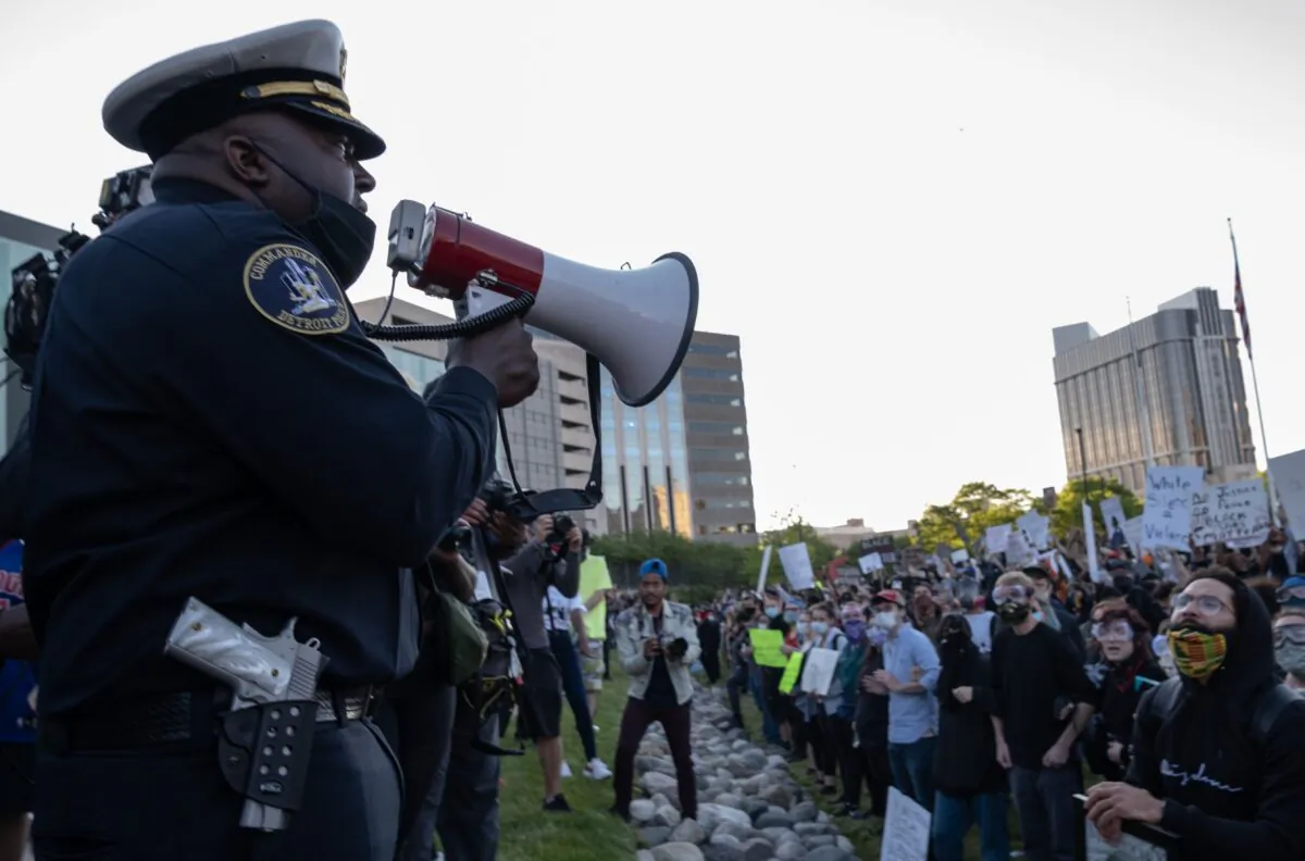 Police officers speak to demonstrators in front of the police station in Detroit, Mich., on May 31, 2020. (Seth Herald/AFP via Getty Images)