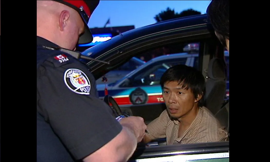 Toronto police question Lu Ping over his delivery of Crescent Chau's anti-Falun Gong tabloid on June 30, 2007, at the Asian Farm grocery store in northeast Toronto. (NTDTV)