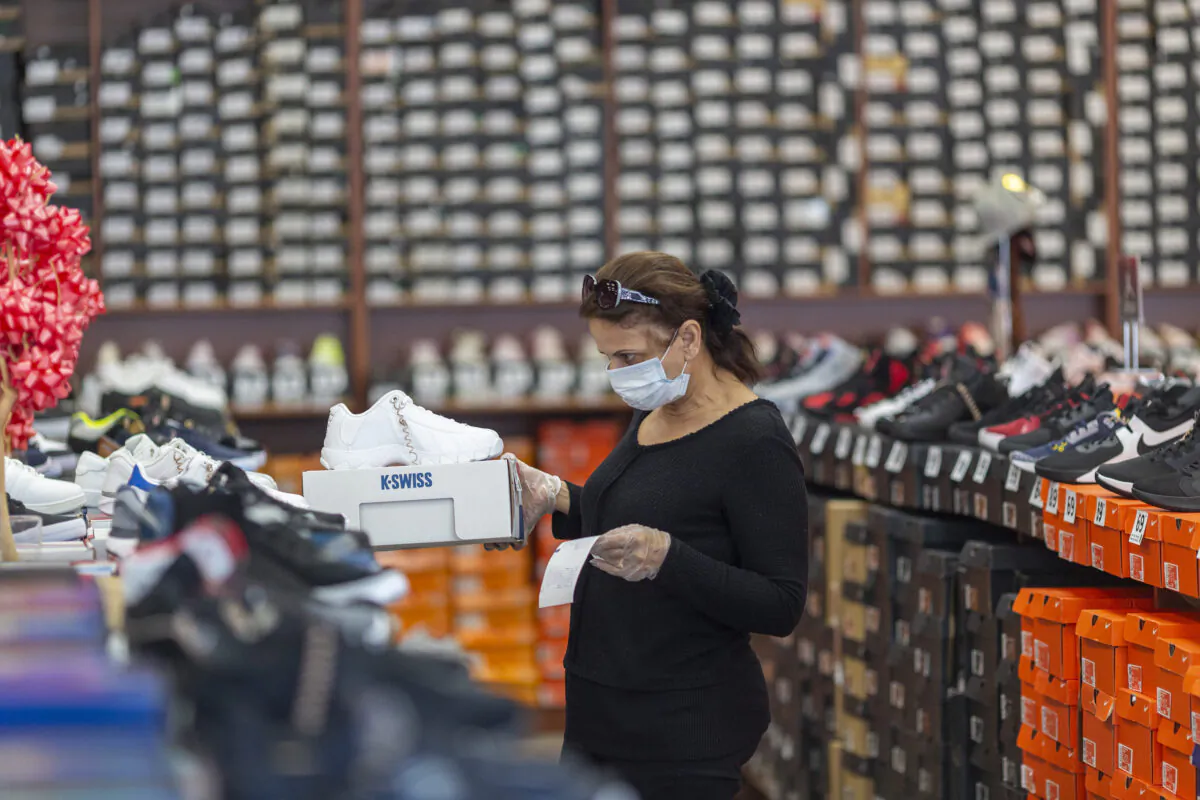 An employee stocks merchandise at a Shoe City store as Los Angeles County retail businesses reopen in Glendale, Calif., on May 27, 2020.    (David McNew/Getty Images)