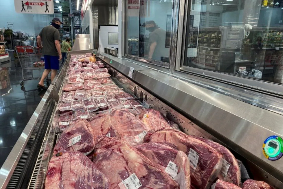 A man wearing a face mask looks toward pork in the meat section of a Costco warehouse club during the COVID-19 pandemic in Webster, Texas, on May 5, 2020. (Adrees Latif/Reuters)